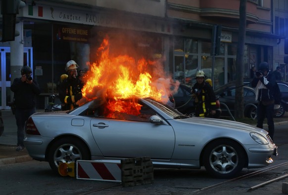 A luxury car that was set on fire by anti-capitalist protesters burns outside the European Central Bank (ECB) building hours before the official opening of its new headquarters in Frankfurt March 18,  ...