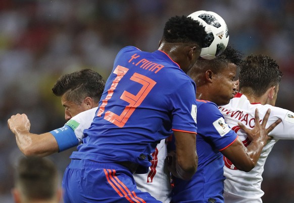 epa06837292 Robert Lewandowski (L) of Poland and Yerry Mina (2-L) of Colombia in action during the FIFA World Cup 2018 group H preliminary round soccer match between Poland and Colombia in Kazan, Russ ...