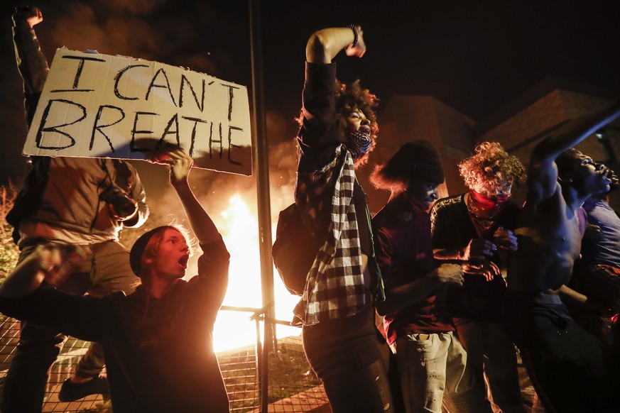 Protestors demonstrate outside of a burning Minneapolis 3rd Police Precinct, Thursday, May 28, 2020, in Minneapolis. Protests over the death of George Floyd, a black man who died in police custody Mon ...