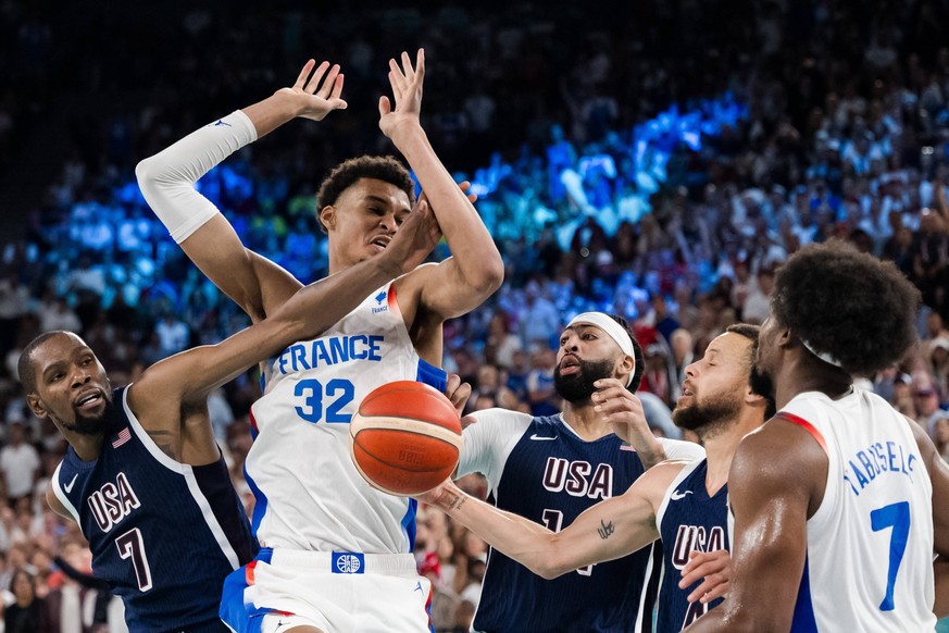 240810 Kevin Durant and Anthony Davis of United States compete for the ball with Victor Wembanyama of France in the men s basketball final between France and USA during day 15 of the Paris 2024 Olympi ...