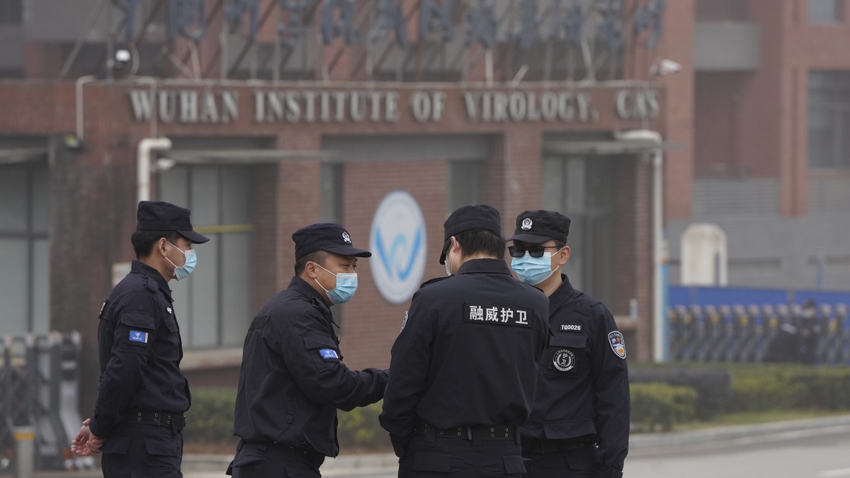 Security personnel gather near the entrance of the Wuhan Institute of Virology during a visit by the World Health Organization team in Wuhan in China's Hubei province on Wednesday, Feb. 3, 2021.  ...