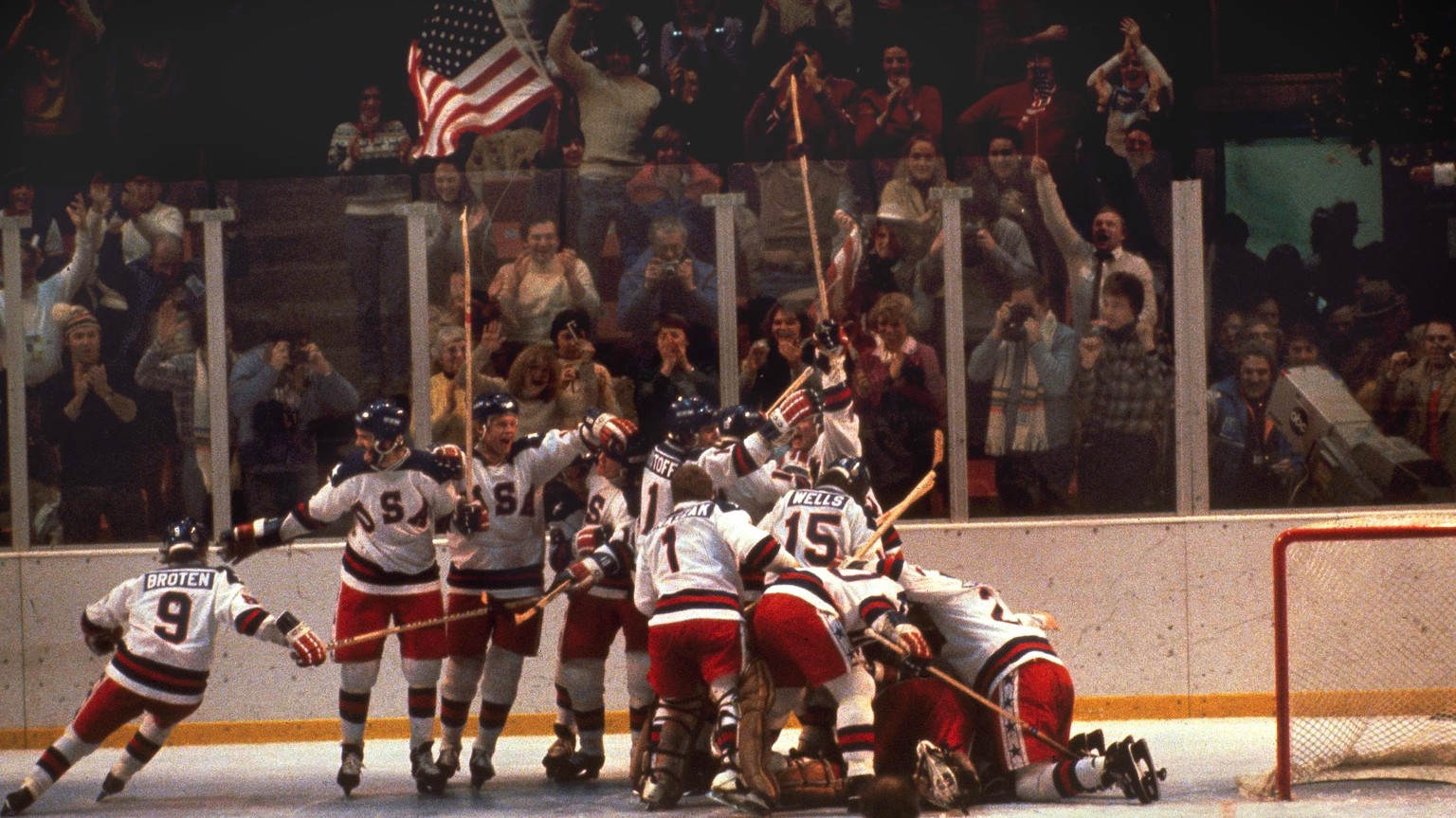 FILE -In this Feb. 22, 1980 file photo, the U.S. hockey team pounces on goalie Jim Craig after a 4-3 victory against the Soviets in the 1980 Olympics, as a flag waves from the partisan Lake Placid, N. ...