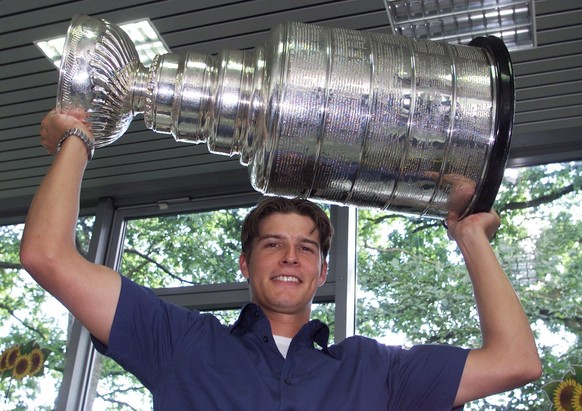 Swiss Ice-Hockey goalie David Aebischer lifts the Stanley Cup he won with his team Colorado Avalanche, Friday, August 31, 2001 in a car dealer&#039;s garage in Fribourg, Switzerland. Aebischer is the  ...