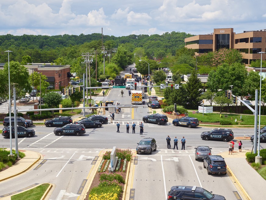 epa06848938 Police and first responders are seen outside the scene of a shooting at the Capital Gazette building (seen in the back right of the image) in Annapolis, Maryland, USA, 28 June 2018. Five w ...