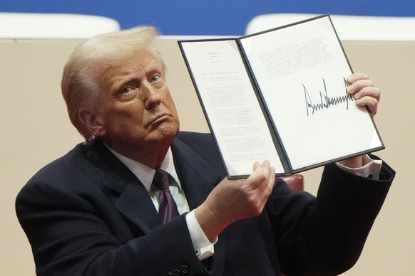 President Donald Trump holds up an executive order after signing it at an indoor Presidential Inauguration parade event in Washington, Monday, Jan. 20, 2025. (AP Photo/Matt Rourke)
Trump 100 Days