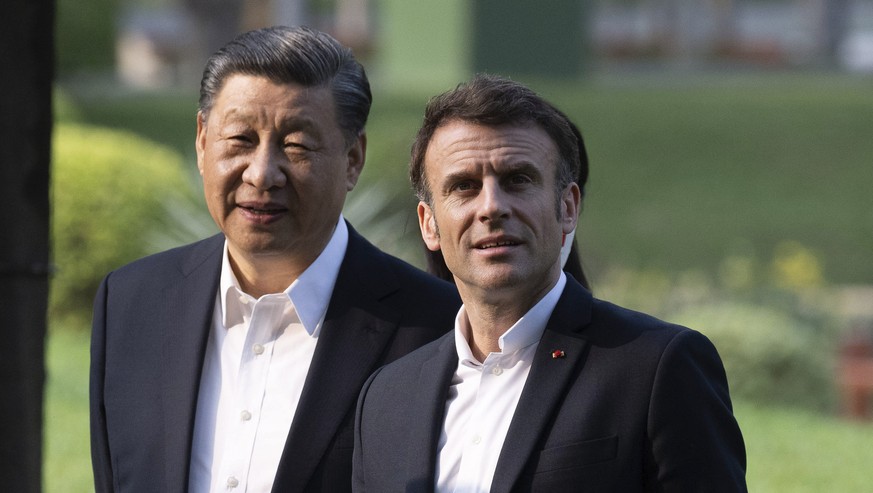 Chinese President Xi Jinping and French President Emmanuel Macron stroll in the garden of the Guandong province governor&#039;s residence, in Guangzhou, China, Friday, April 7, 2023. (Jacques Witt, Po ...