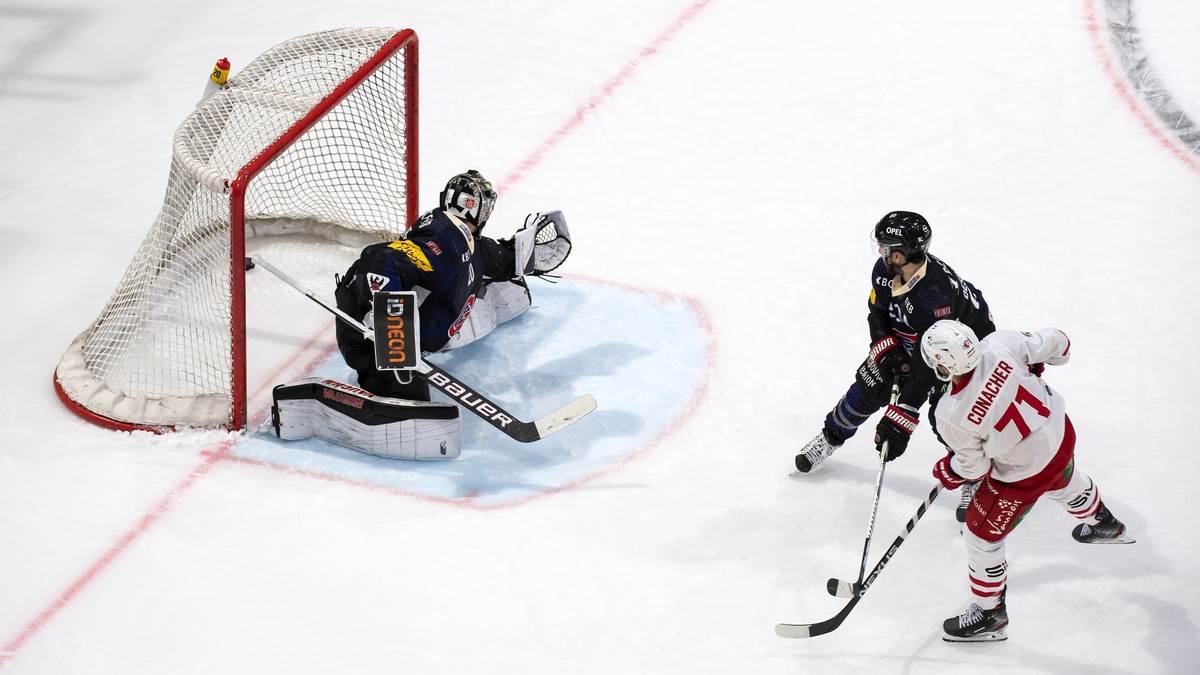 L'attaquant lausannois Cory Conacher, droite, marque le premier but au gardien Fribourgeois Reto Berra, gauche, lors du match du championnat suisse de hockey sur glace de National League entre le ...