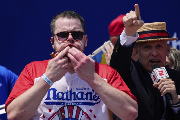 Patrick Bertoletti stuffs hot dogs into his mouth during the men&#039;s division in Nathan&#039;s Famous Fourth of July hot dog eating contest, Thursday, July 4, 2024, at Coney Island in the Brooklyn  ...
