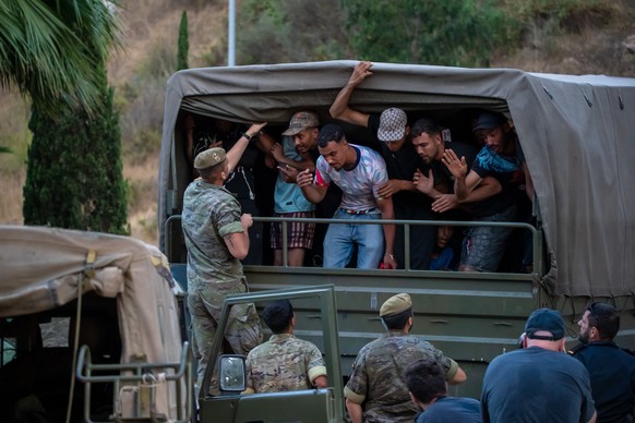 Migrants who crossed into Spain are escorted by Spanish soldiers towards the Spanish-Moroccan border for their return to Morocco from the Spanish enclave of Ceuta, Sunday, Aug. 2, 2026. (AP Photo/Anto ...