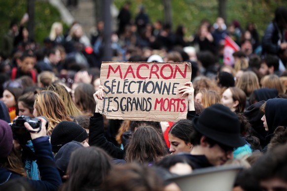 epa07214462 A French student holds a sign reading &#039;Macron, choose your great dead people&#039;, during in a demonstration against the increase of the subscription fees for foreigners students, in ...