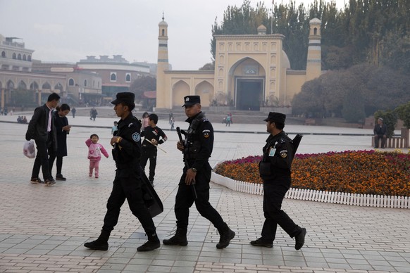 FILE - In this Nov. 4, 2017 file photo, Uighur security personnel patrol near the Id Kah Mosque in Kashgar in western China&#039;s Xinjiang region. Classified documents, leaked to a consortium of news ...