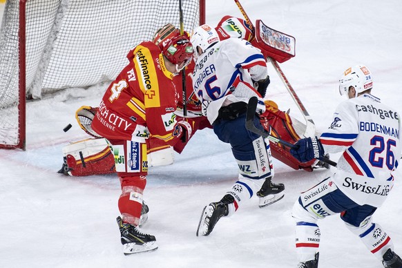 Biels Kevin Fey, links, und Goalie Jonas Hiller, Mitte, sind geschlagen, Zuerichs Marcus Krueger trifft zum 3:2 im Eishockey Meisterschaftsspiel der National League zwischen dem EHC Biel und den ZSC L ...