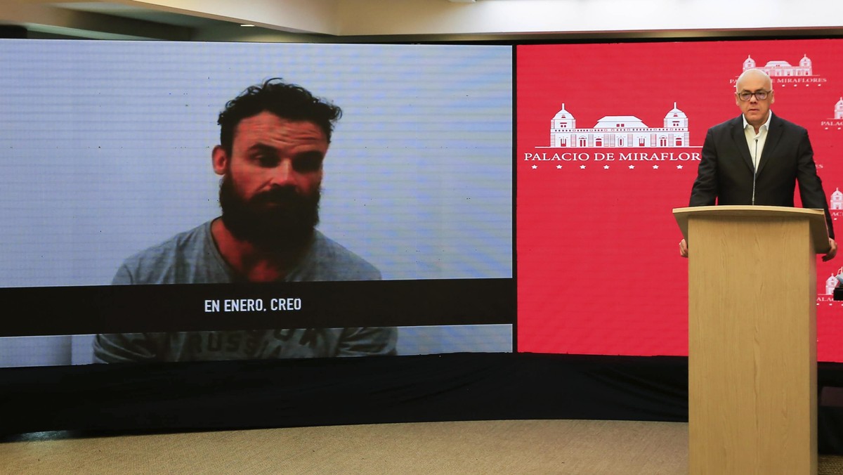 In this photo released by Venezuela's Ministry of Communication, Jorge Rodriguez shows a video of American Airon Berry, a former U.S. special forces soldier associated with the Florida-based priv ...