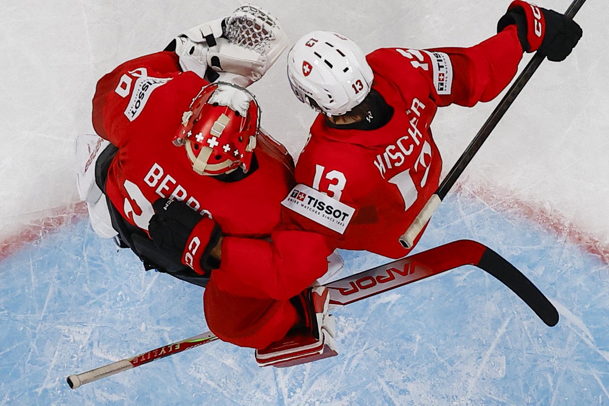 epa12982582 Switzerland's goaltender Reto Berra (L) and Nico Hischier celebrate winning the 2026 IIHF Men's Ice Hockey World Championship preliminary round group A game between Switzerland a ...