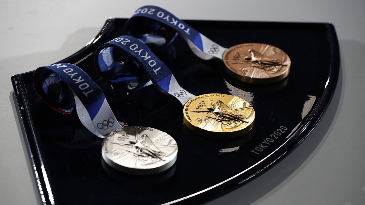 epa09244501 Three medals sit on a medal tray that will be used in the award ceremonies at the Tokyo Olympic Games, during an unveiling event at Ariake Arena, in Tokyo, Japan, 03 June 2021. EPA/ISSEI K ...