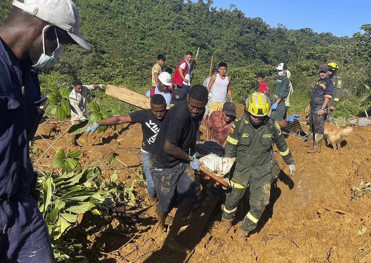 In this handout photo released by the Colombian Army Press Office, a rescue team recovers the body of a mudslide victim, that killed several people and left dozens injured, in western Colombia, Saturd ...