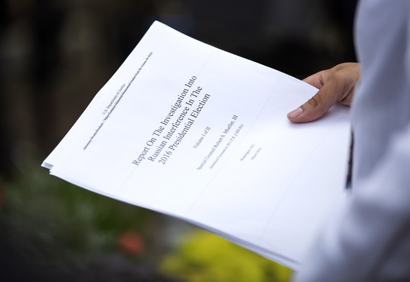 epa07514219 A reporter holds a printout of the redacted version of Special Counsel Robert Mueller&#039;s report on Russian interference in the 2016 election minutes after its release outside the US De ...