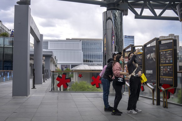 People pose for a selfie on an empty concourse at a shopping center normally busy on weekends, after most businesses were ordered to close as part of COVID-19 restrictions in the Chaoyang district in  ...