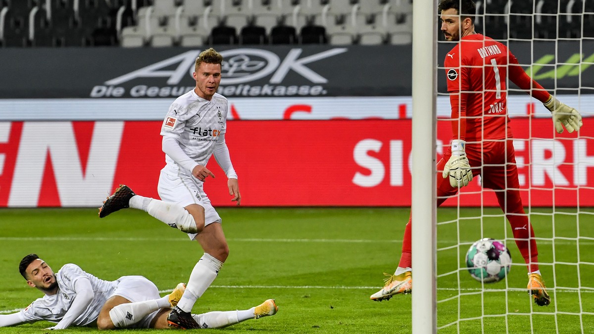 Moenchengladbach's Nico Elvedi, center, scores the opening goal during the German Bundesliga soccer match between Borussia Moenchengladbach and Borussia Dortmund in Moenchengladbach, Germany, Fri ...