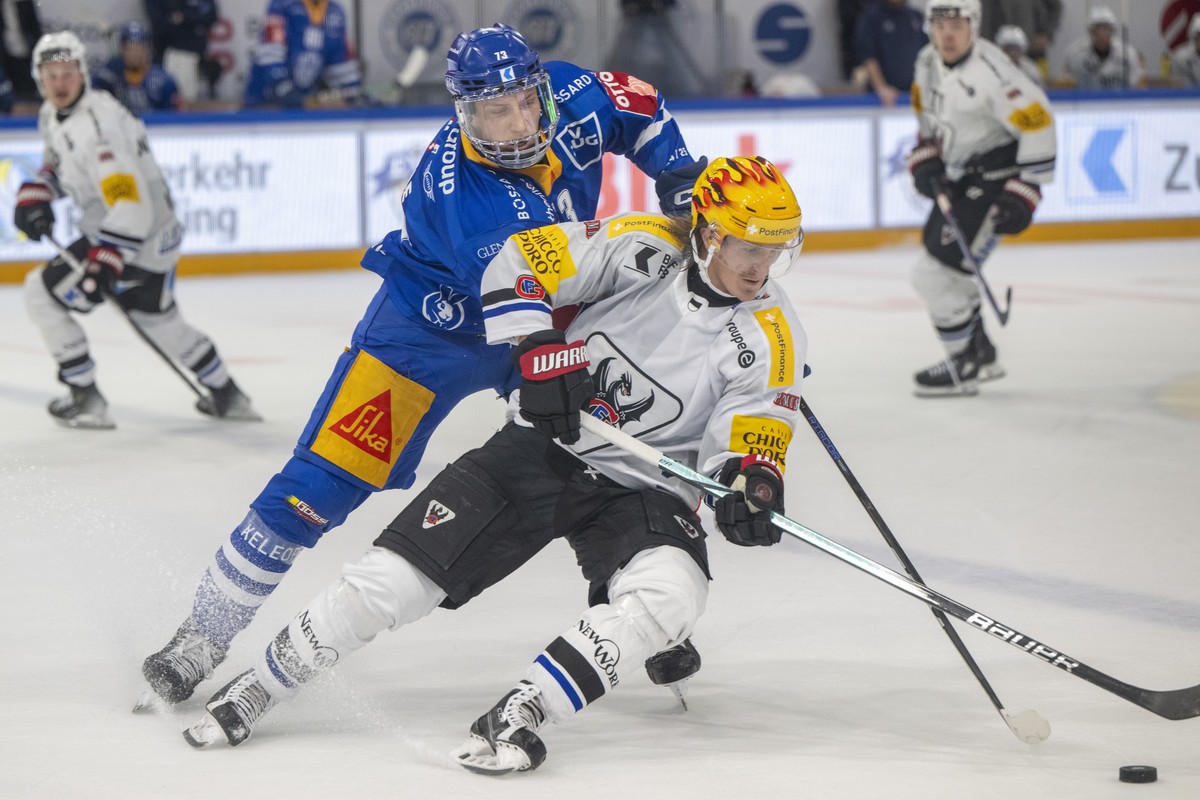 Mike Kuenzle, links, von Zug im Spiel gegen PostFinance Top Scorer Marcus Soerensen, rechts, von Fribourg beim Eishockey Qualifikationsspiel der National League zwischen dem EV Zug und dem HC Fribourg ...