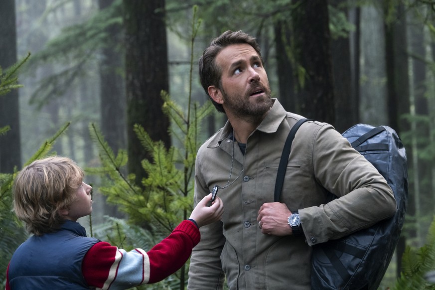 This image released by Netflix shows Walker Scobell, left, and Ryan Reynolds in a scene from &quot;The Adam Project.&quot; (Doane Gregory/Netflix via AP)