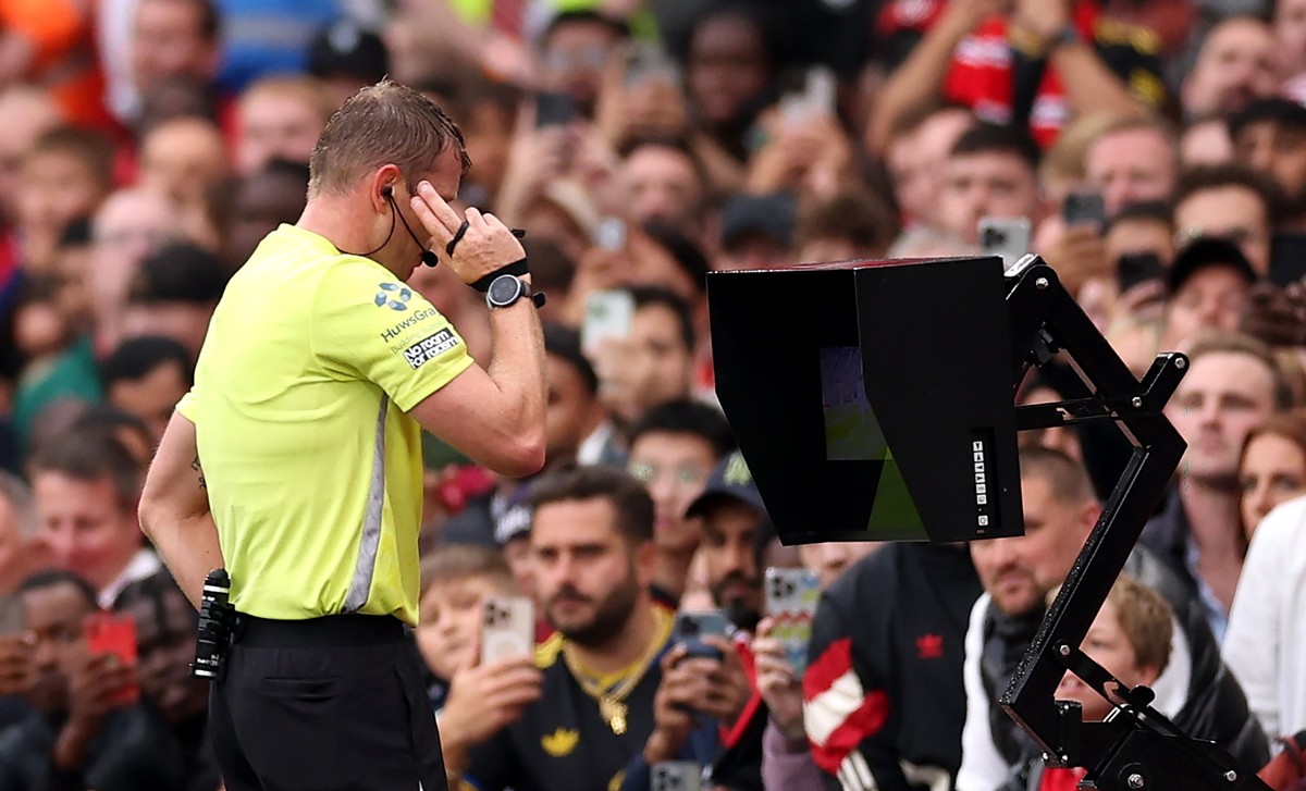 epa12337163 Referee Samuel Barrott does a VAR check for a potential penalty in added time during the English Premier League soccer match between Manchester United and Burnley FC, in Manchester, Britai ...