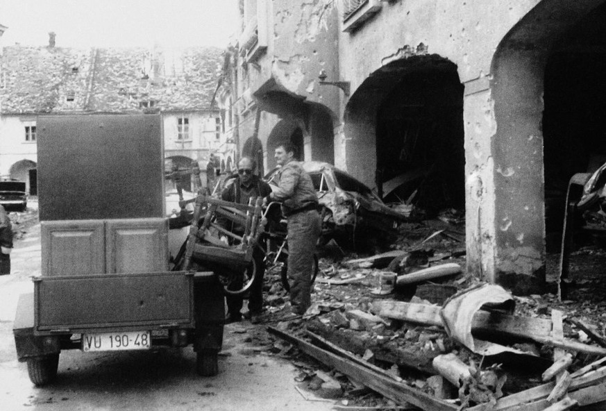 Ein Einwohner der kroatischen Stadt Vukovar flüchtet im November 1991 mit übrig gebliebenen Habseligkeiten aus den Ruinen seines Hauses.