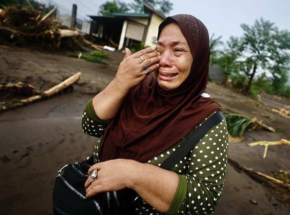 epa11681940 A villager reacts after learning about her destroyed home in the aftermath of Tropical Storm Trami, in the flood-hit town of Laurel, Batangas province, Philippines, 25 October 2024. At lea ...