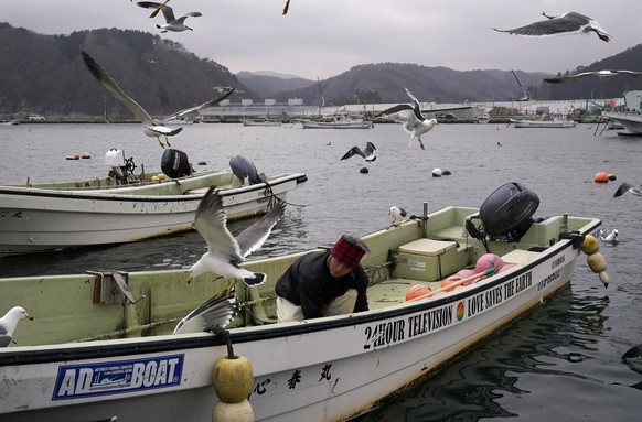 epa09061943 A fisherman cuts a fish on his boat after fishing at a port of Taro district devastated by the 2011 tsunami and earthquake, in Miyako, Iwate prefecture, northern Japan, 22 February 2021 (i ...