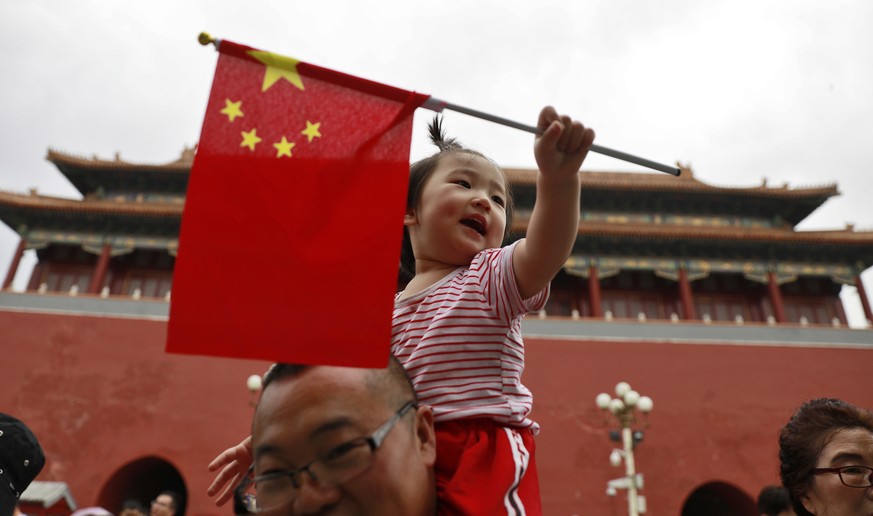 epa06781799 A Chinese girl holds up the national flag inside the Forbidden City across Tiananmen Square on the eve of the 29th anniversary of the 1989 June 4th Tiananmen Square protests in Beijing, Ch ...