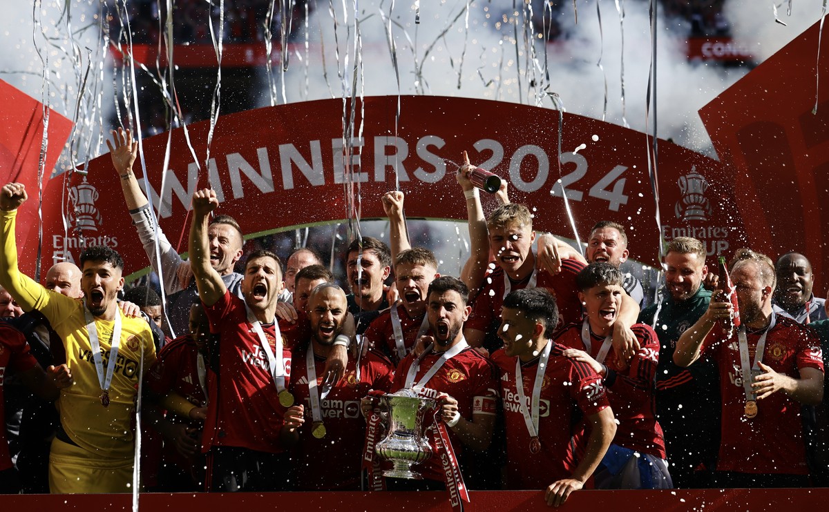 epa11368991 Manchester United's players celebrate with the trophy after winning the English FA Cup final match of Manchester City against Manchester United, in London, Britain, 25 May 2024. EPA/T ...