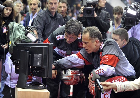 Referee&#039;s Brent Reiber, left and Danny Kurmann, right, watch an action replay of a disputed scene on a screen during the sixth leg of the Playoffs Final game of National League A (NLA) Swiss Cham ...