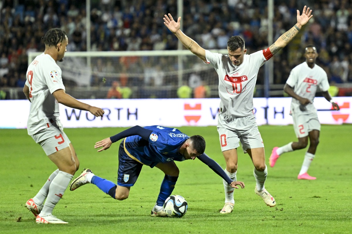Kosovo's mitfielder Edon Zhegrova, center, fights for the ball with Switzerland's midfielder Granit Xhaka, right, and Switzerland's forward Noah Okafor, left, during the UEFA Euro 2024  ...