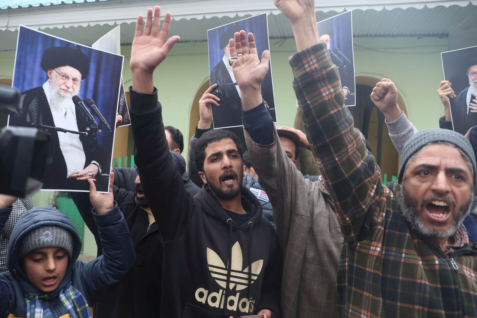 epa12652951 Kashmiri Shiite Muslims shout slogans and hold photographs of Iran's supreme leader Ayatollah Syed Ali Khamenei during a protest against the US and Israel in Srinagar, the summer capi ...