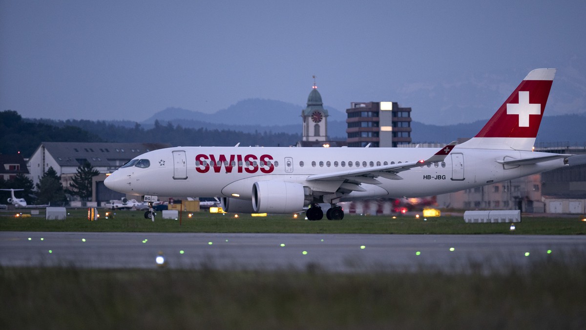 ZUM FLUGHAFEN ZUERICH IM DAEMMERLICHT UND BEI NACHT STELLEN WIR IHNEN FOLGENDES NEUES BILDMATERIAL ZUR VERFUEGUNG --- An Airbus Airbus A220-100 aircraft from Swiss International Air Lines (SWISS) at Z ...