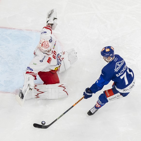 Zuerichs Jerome Bachofner, rechts, schiesst den Puck gegen SC Rapperswil-Jona Lakers Torhueter Melvin Nyffeler im Eishockeyspiel der National League zwischen den ZSC Lions und dem SC Rapperswil-Jona L ...