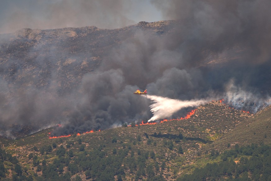 KEYPIX - A seaplane drops water onto the fire as a wildfire advances near La Adrada, ? vila province, Spain, Friday, July 24, 2026. (AP Photo/Manu Fernandez)