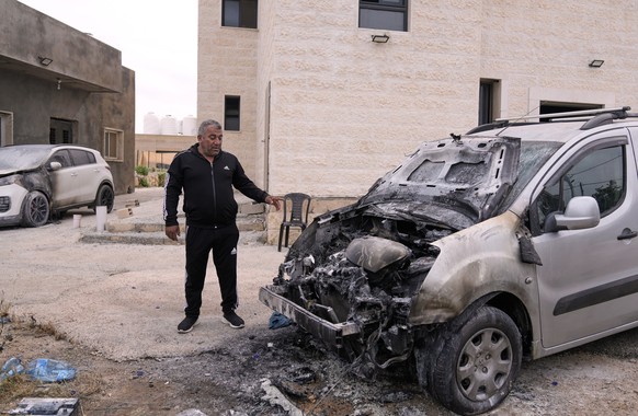 Imam Saber Shalash shows fire-damaged cars parked near the local mosque following an attack by Israeli settlers, condemned by Palestinian authorities, in the West Bank village of Jibiya, northwest of  ...