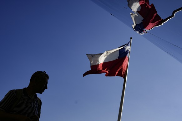 FILE - A Chilean flag flies at the Biennial of Architecture and Urbanism show in Santiago, Chile, Jan. 19, 2023. Congress approved on April 11, 2023 a law gradually reducing the work week from 45 to 4 ...