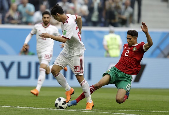 Iran&#039;s Sardar Azmoun, left, and Morocco&#039;s Achraf Hakimi, fight for the ball, during the group B match between Morocco and Iran at the 2018 soccer World Cup in the St. Petersburg Stadium in S ...