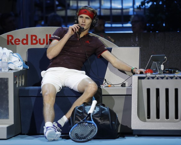 Alexander Zverev talks to his coach by headphones during a break of an exhibition match against Stefanos Tsitsipas at the ATP Next Gen tennis tournament finals, in Rho, near Milan, Italy, Tuesday, Nov ...