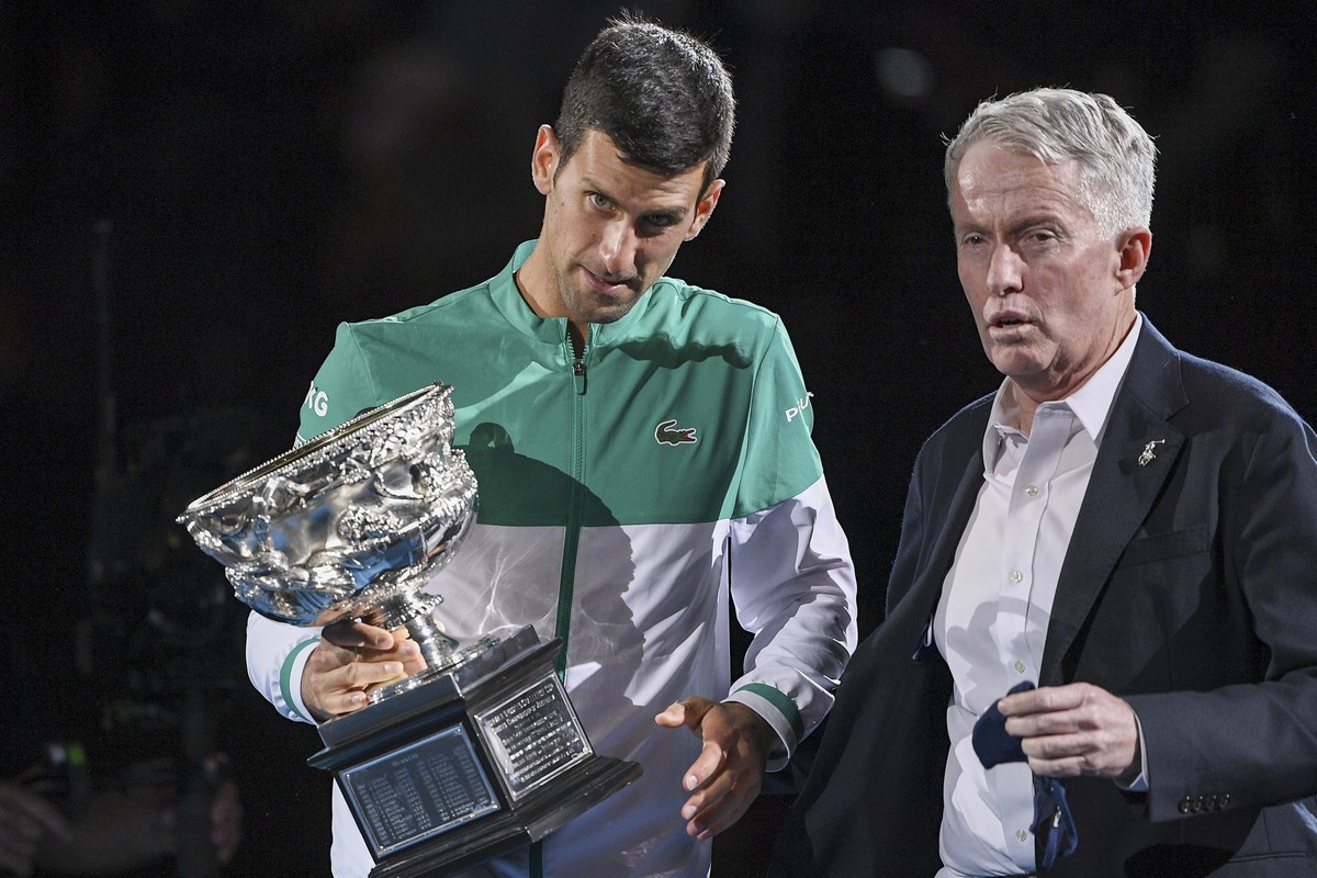 Serbia's Novak Djokovic, left, stands with Australian Open tournament director Craig Tiley during the trophy presentation at the Australian Open tennis championships in Melbourne, Australia, Sund ...