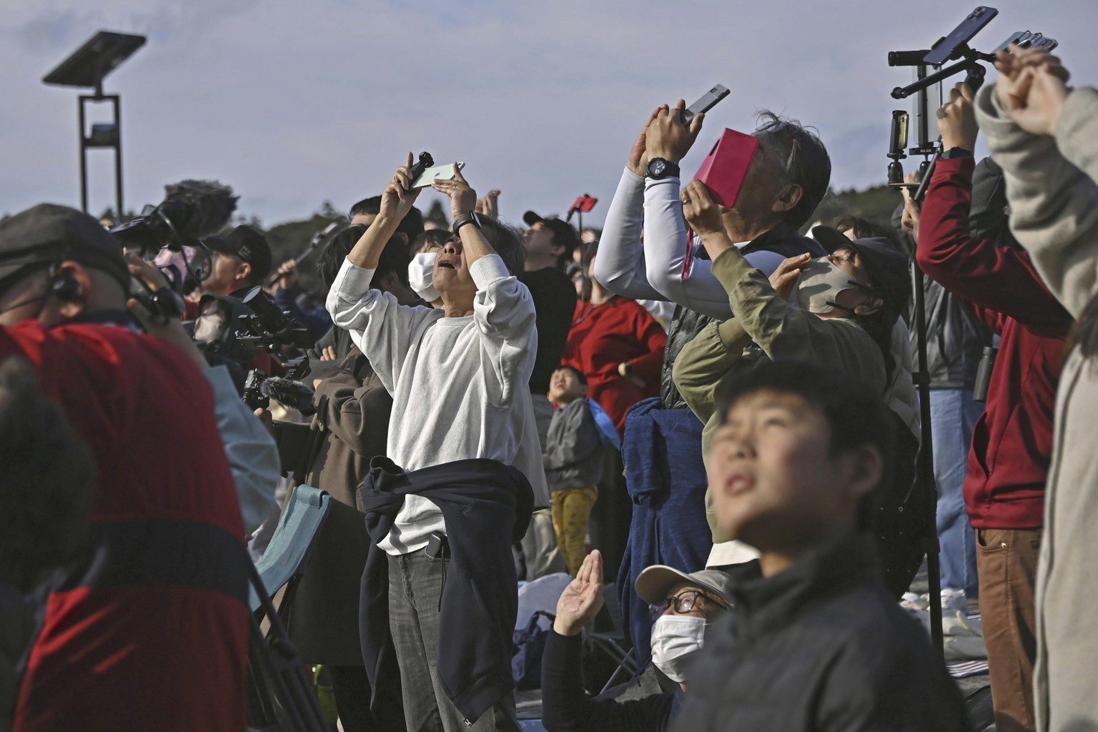 People in Minamitane town, Kagoshima, southern Japan, watch as an H3 rocket lifts off from Tanegashima Space Center Saturday, Feb. 17, 2024. (Kyodo News via AP)