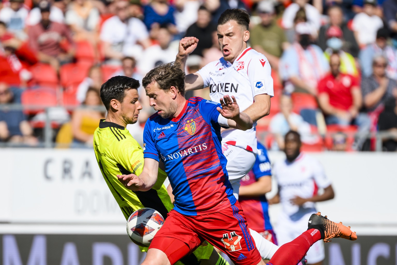 Le gardien balois Heinz Lindner, gauche, et le joueur balois Fabian Frei, centre, luttent pour le ballon avec l&#039;attaquant valaisan Filip Stojilkovic, droite, lors de la rencontre du championnat d ...