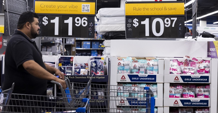 epa10123380 A customer pushes a shopping cart at a Walmart in Washington, DC, USA, 15 August 2022. Walmart Inc. will report fiscal second quarter earnings this week. While inflation in the United Stat ...