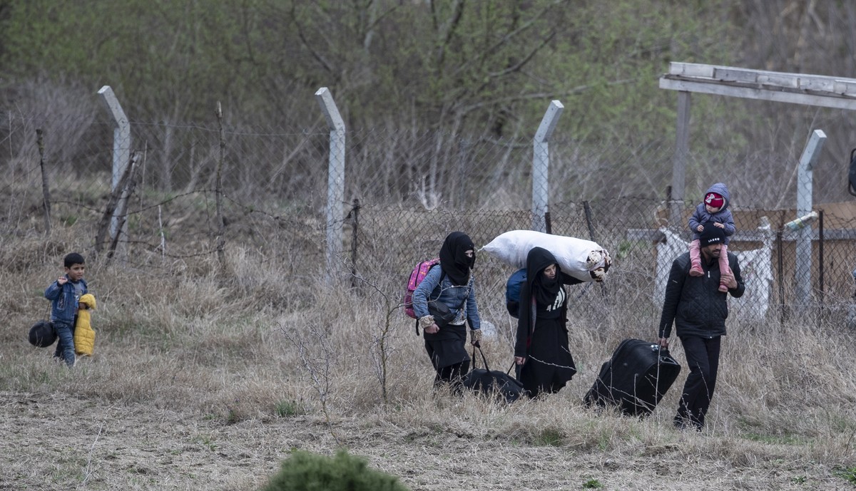 epa08283578 A refugee family walks by small river in Edirne city center as they try to reach to the Greek border in Edirne, Turkey, 10 March 2020. About 35,000 migrants have massed at Turkey's bo ...