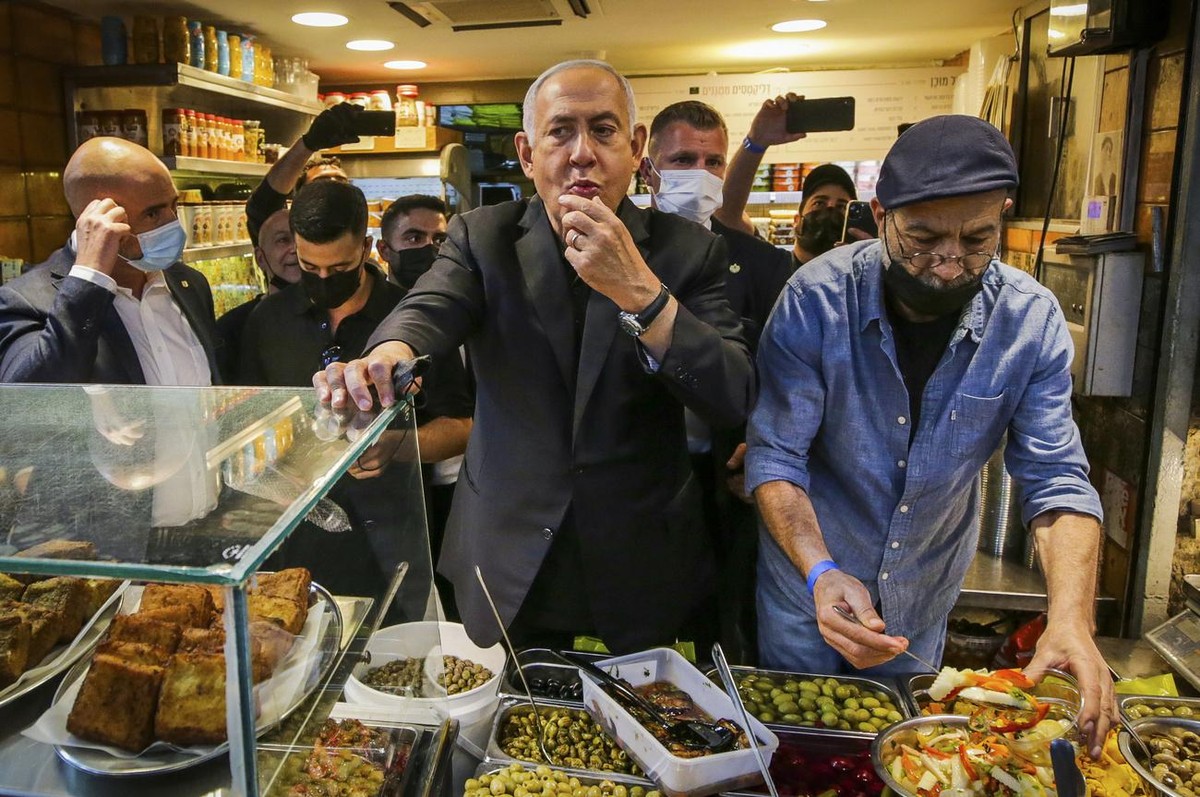 Israeli Prime Minister Benjamin Netanyahu, center, tours the Mahane Yehuda market while campaigning a day before national elections, in Jerusalem, Monday, March 22, 2021. The March 23 vote is Israel�� ...