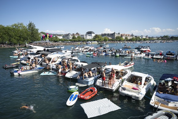 Participants watch the Street Parade from a boat during the 33rd Street Parade in the city center of Zurich, Switzerland, Saturday, August 8, 2026. The annual dance music event Street Parade runs this ...