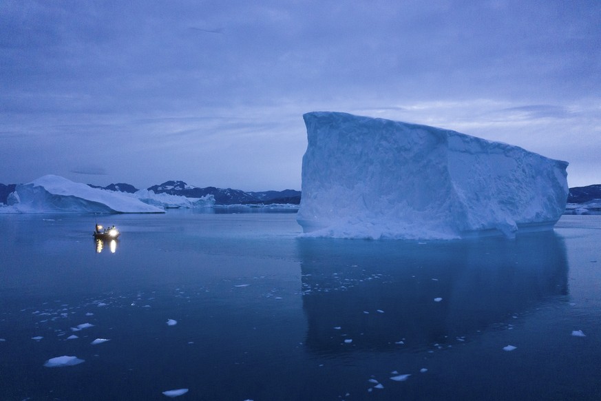 CORRECTING DATE TO 20 - In this Aug. 15, 2019, photo, a boat navigates at night next to icebergs in eastern Greenland. U.S. President Trump announced his decision to postpone a visit to Denmark by twe ...