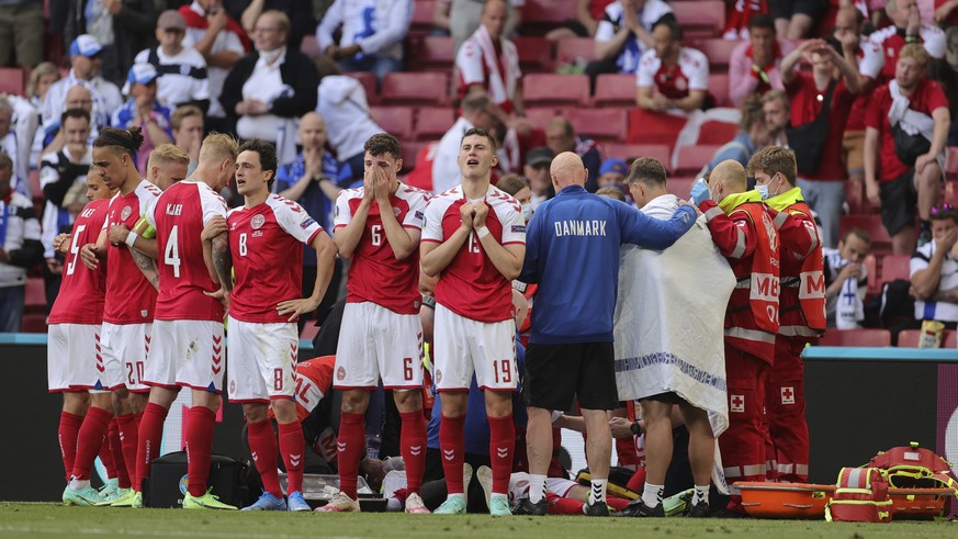 Denmark players react after the collapsing of their teammate Christian Eriksen during the Euro 2020 soccer championship group B match between Denmark and Finland at Parken stadium in Copenhagen, Denma ...